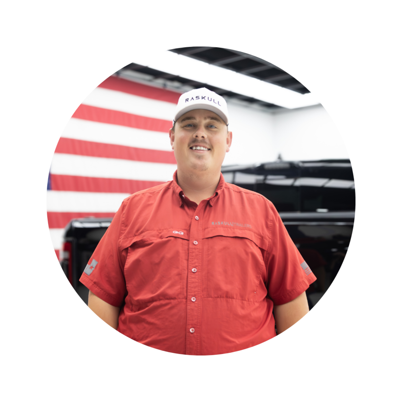Man wearing a red shirt and cap with a truck and American flag in the background